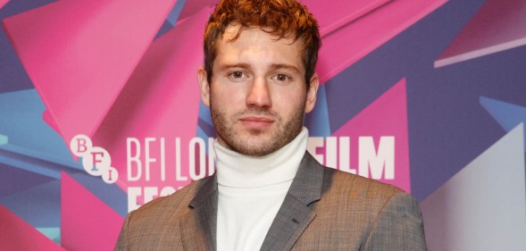 Actor Alexander Lincoln wearing a silver grey suit jacket over a white turtleneck sweater poses for the cameras at the London Film Festival. (Getty)