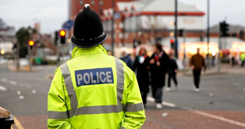 A policeman patrols in a high vis jacket around a city centre.