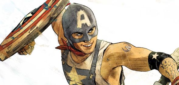 Aaron Fischer in a navy blue mask with the letter A on it and a pair of dungarees, while holding a Captain American shield.