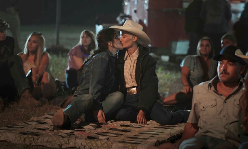 A still from Yellowstone showing actor Lilli Kay (L) as Clara kissing her real-life partnerJuli Kocemba during the series' midseason finale. (Paramount)