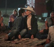 A still from Yellowstone showing actor Lilli Kay (L) as Clara kissing her real-life partnerJuli Kocemba during the series' midseason finale. (Paramount)