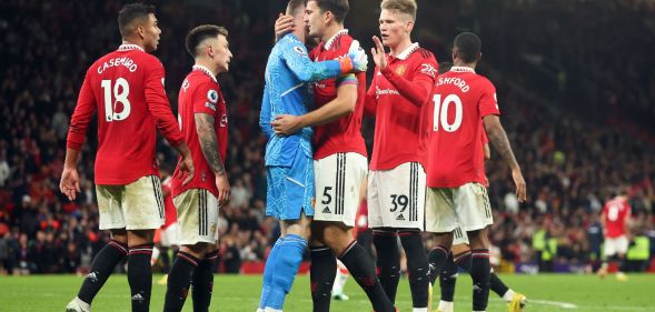 Manchester United players, wearing red football uniforms, gather around each other