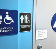 Signs on a wall show members of the public that the bathroom is an 'all gender restroom' and inclusive of trans people