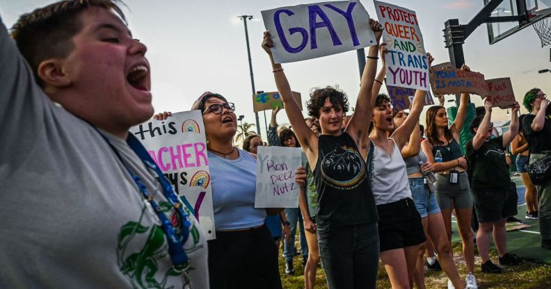 LGBTQ+ rights advocates gather around in protest of Ron DeSantis and the 'Don't Say Gay' bill in protest