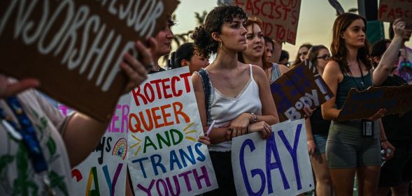 LGBTQ+ rights advocates gather around in protest of Ron DeSantis and the 'Don't Say Gay' bill in protest