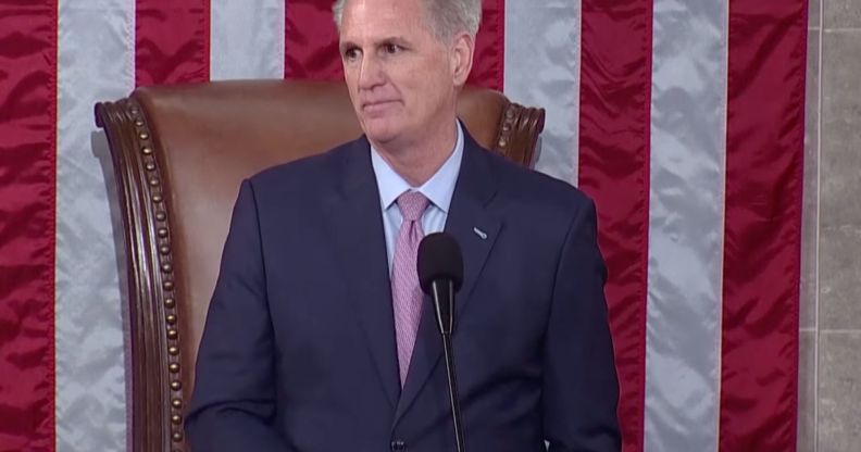 Republican congressman Kevin McCarthy, who is wearing a suit and tie, stands at a podium in front of the red, white and blue US flag as he's sworn in as speaker of the House of Representatives