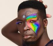 A photo shows a close-up of Kenyan LGBTQ+ activist Edwin Chiloba wearing rainbow and glitter makeup with his hand behind his head