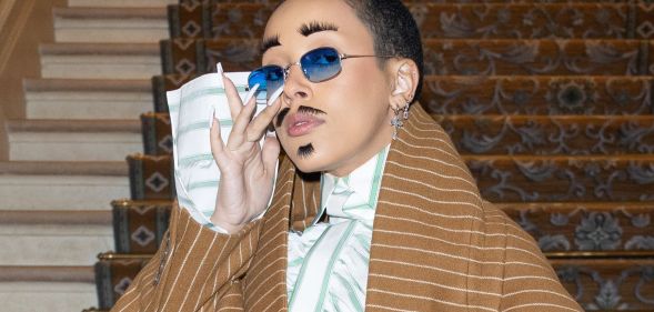 A photo of American rapper Doja Cat wearing eyelashes as eyebrows and as a moustache at Paris Fashion Week