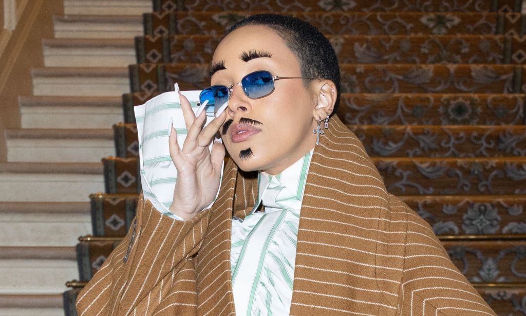 A photo of American rapper Doja Cat wearing eyelashes as eyebrows and as a moustache at Paris Fashion Week