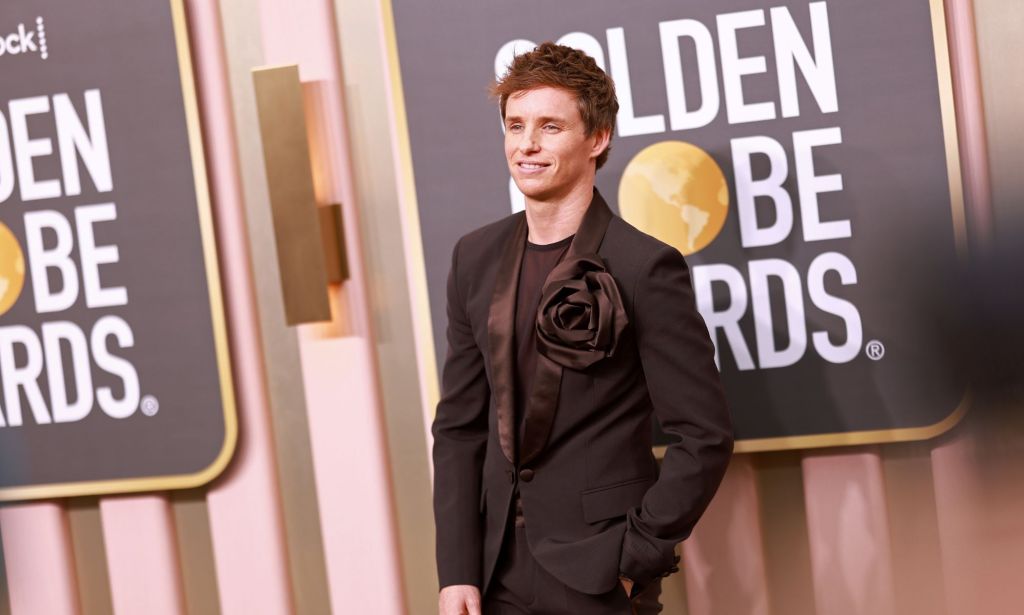 Eddie Redmayne in a black suit on the red carpet at the Golden Globes.