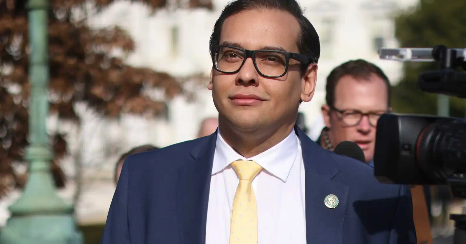 George Santos in a blue suit, white shirt and yellow tie