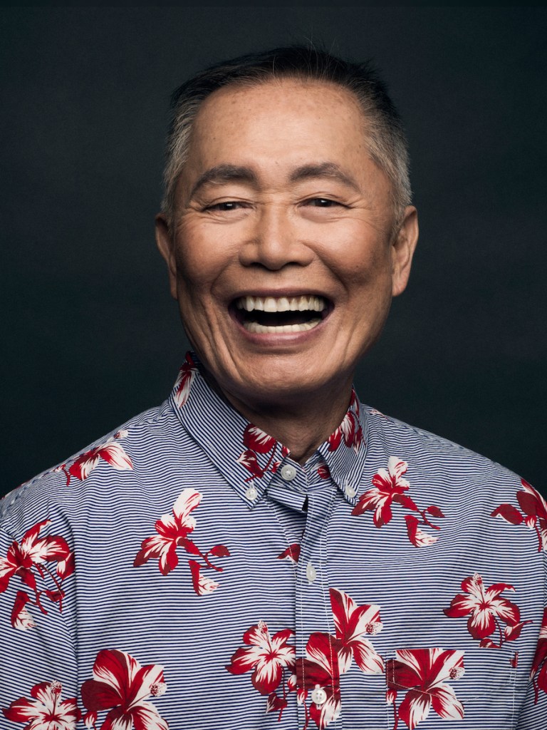 George Takei laughing in a floral shirt