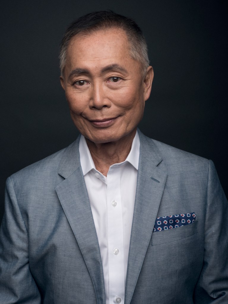 George Takei in a grey suit jacket and white shirt