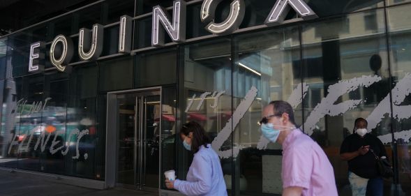 Two people walk past an Equinox gym in New York