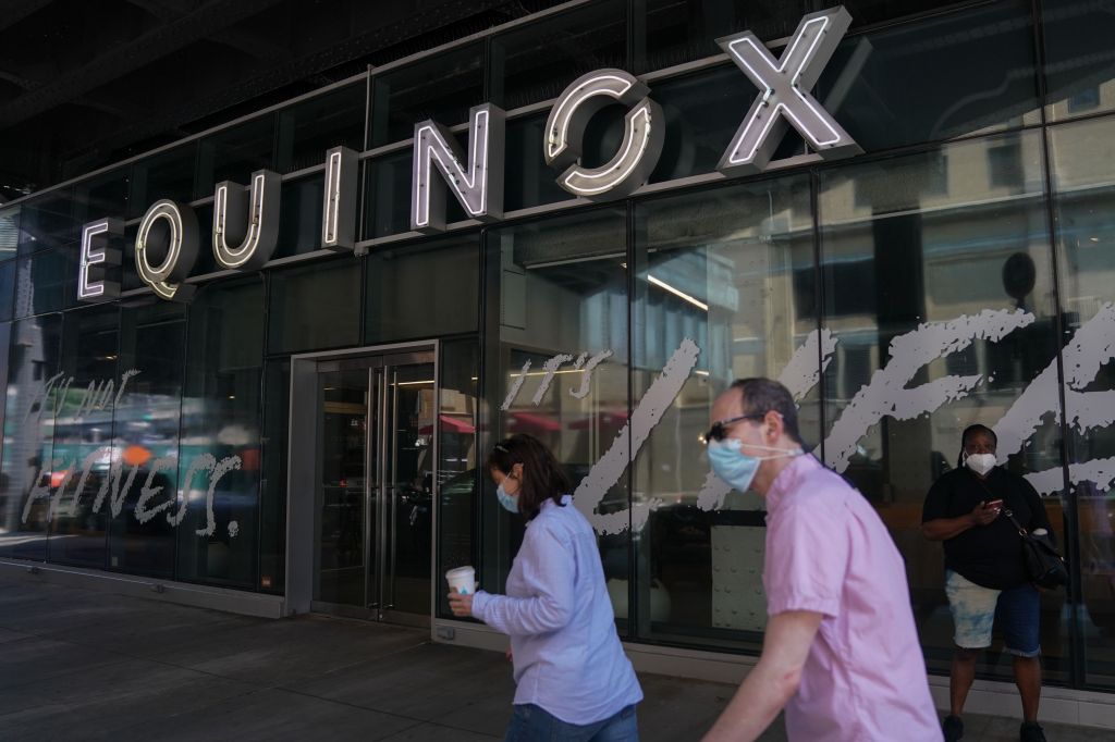 Two people walk past an Equinox gym in New York