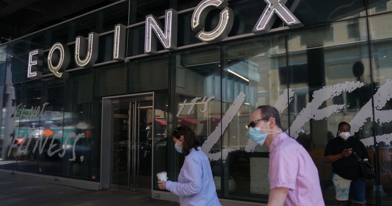 Two people walk past an Equinox gym in New York