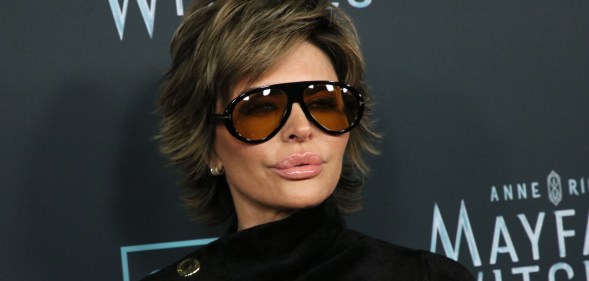 Lisa Rinna wearing sunglasses against a black background