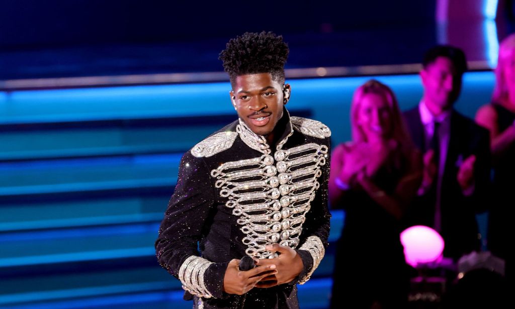 Lil Nas X performs at the 2022 Grammy Awards in a black and silver jacket.