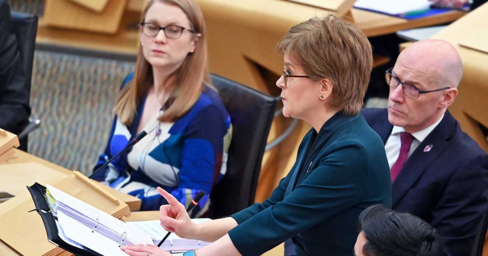 A screenshot of Nicola Sturgeon wearing a navy suit as she talks during First Ministers Questions at the Scottish Parliament