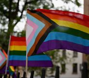 LGBTQ+ progress flags wave in an American street.