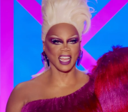 RuPaul judging Drag Race UK season 4 in a blonde wig and red and pink dress