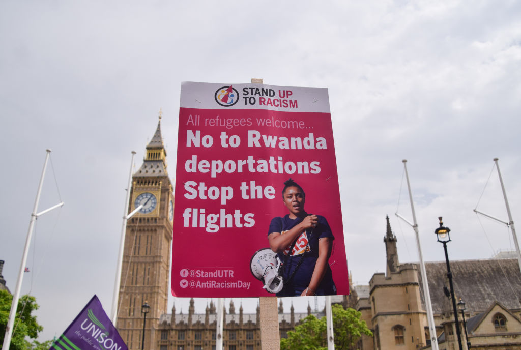 A placard opposing the deportation of refugees to Rwanda is seen during a demonstration in Parliament Square. The placard reads "No to Rwanda deportations. Stop the flights".