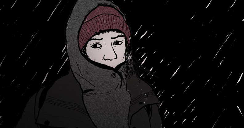 An illustration shows a person wrapped up in a coat as rain falls in the background. It is night time and the person looks heartbroken.