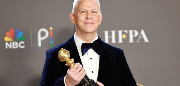 Ryan Murphy holding his Golden Globe Carol Burnett Award
