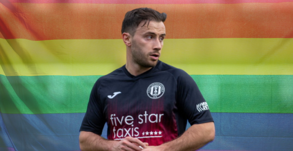 Zander Murray in front of an LGBTQ flag