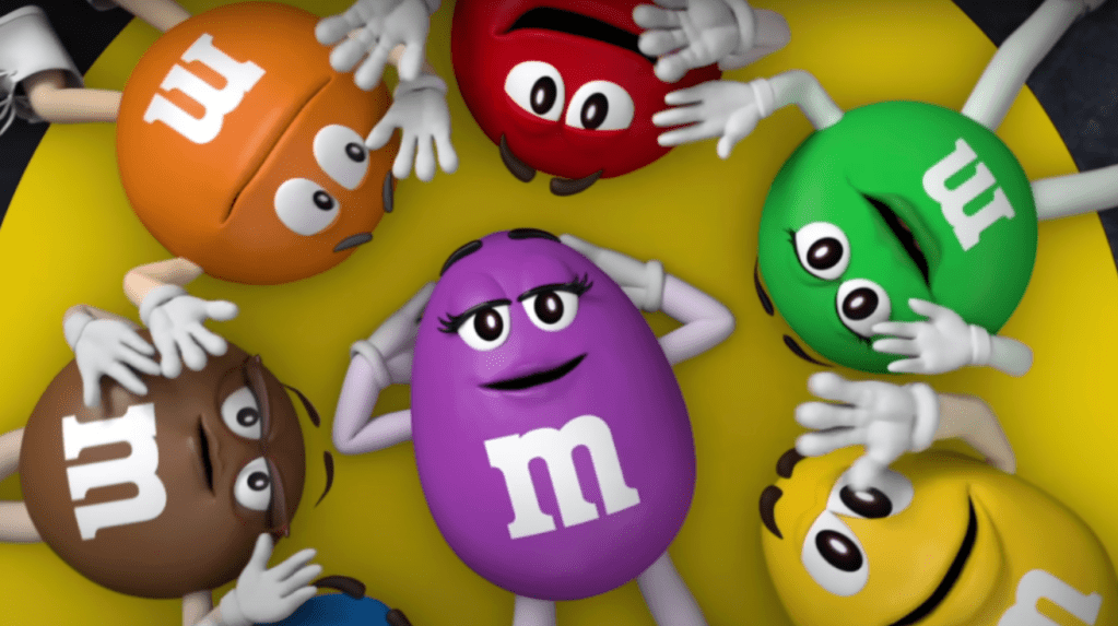 M&Ms characters in a circle surrounding the cartoon purple M&M