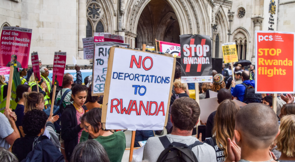 A protester holds a placard which states "No deportations to Rwanda" during a demonstration to halt deportations of refugees to Rwanda