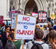 A protester holds a placard which states "No deportations to Rwanda" during a demonstration to halt deportations of refugees to Rwanda