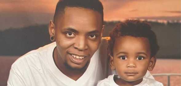 Trans dad Tanius Posey wearing a white top is pictured with his baby Za’nius who is also dressed in white