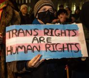 A protestors holds up a sign reading 'trans rights are human rights.'
