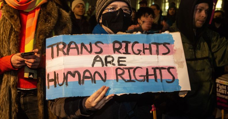 A protestors holds up a sign reading 'trans rights are human rights.'