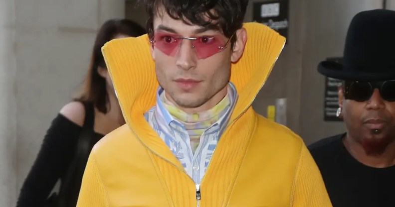 Ezra Miller in a yellow coat and sunglasses