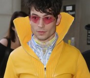 Ezra Miller in a yellow coat and sunglasses