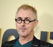 Alan Cumming in black glasses with blonde hair