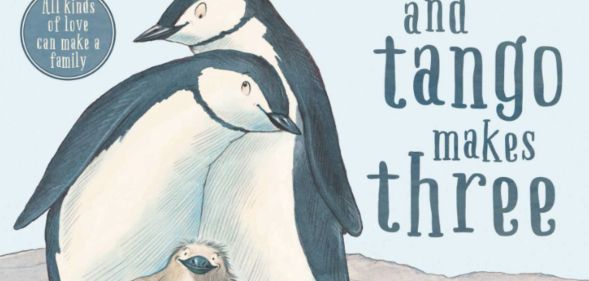 A cover of the book And Tango Makes Three featuring two adult penguins leaning into each other with a baby chick nestled in between them