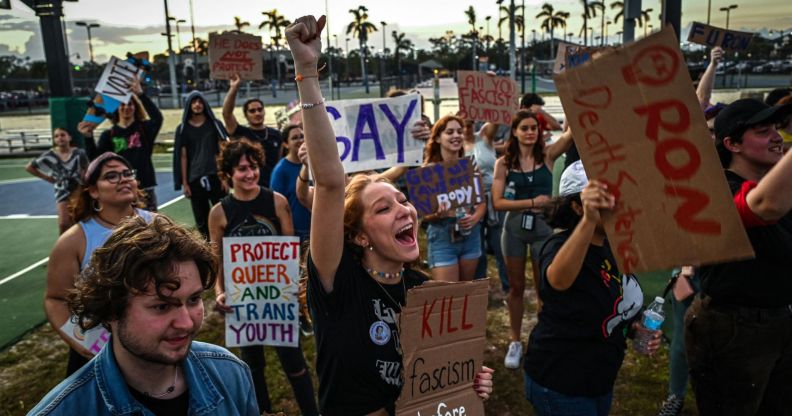 People hold up signs in support of the LGBTQ+ community as they protest against Florida governor Ron DeSantis, who championed the state's 'Don't Say Gay' bill
