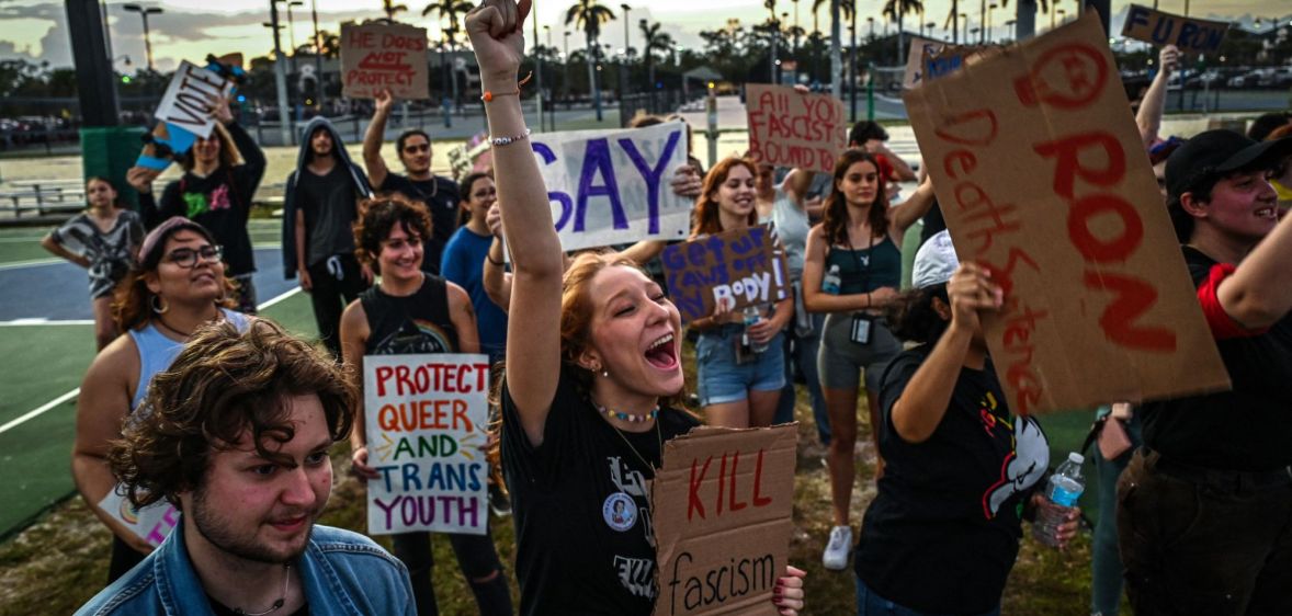 People hold up signs in support of the LGBTQ+ community as they protest against Florida governor Ron DeSantis, who championed the state's 'Don't Say Gay' bill