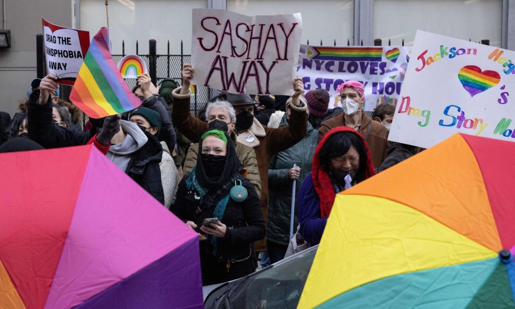 Several people hold up rainbow LGBTQ+ pride colours and signs in support of a drag event that was targeted by right-wing protestors