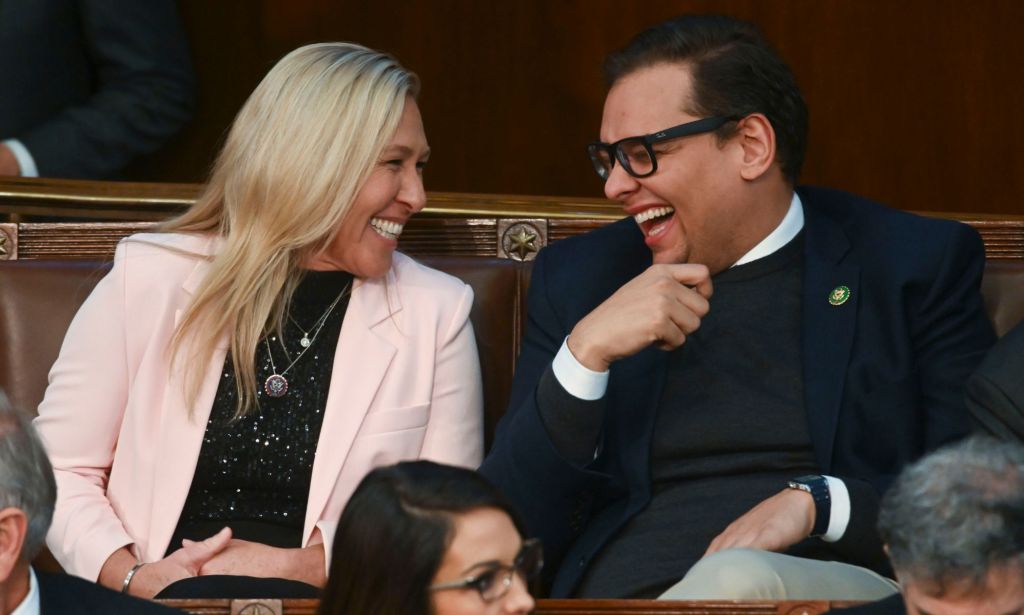 Marjorie Taylor Greene laughs while speaking with George Santos in the House of Representatives