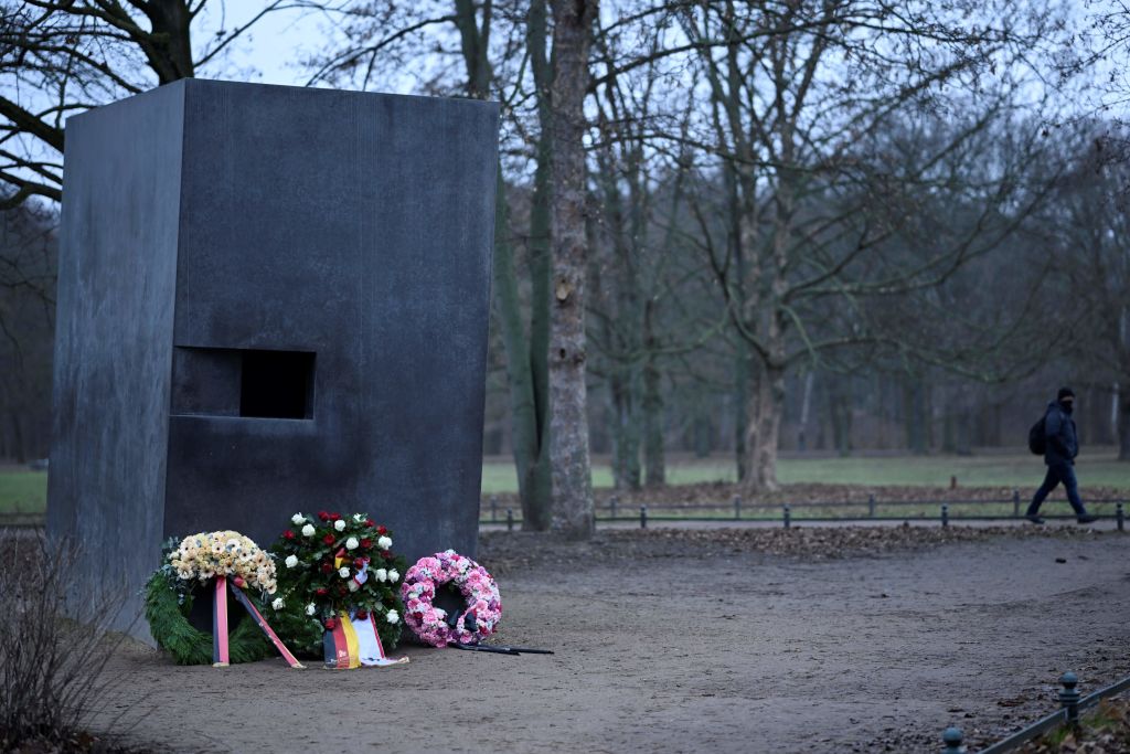A photo taken on January 26, 2023 shows wreaths laid in front of the Memorial to Homosexuals Persecuted Under Nazism. The large stone memorial is pictured against a desolate landscape of trees and a grey sky.