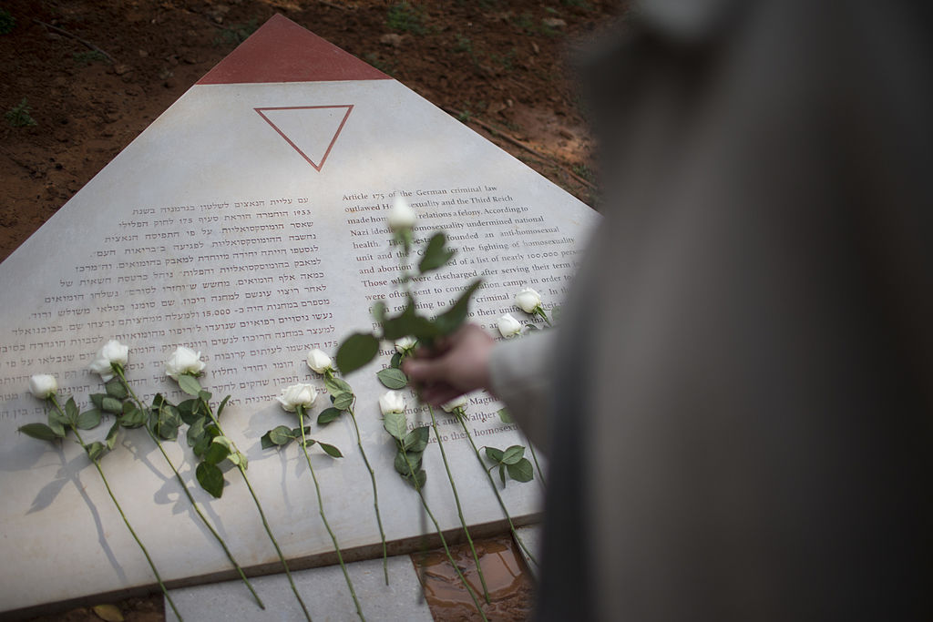 A man lays a white rose at a memorial inaugurated to lesbian, gay, bisexual, and transgender victims of the Holocaust on January 10, 2014 in Tel Aviv, Israel. 