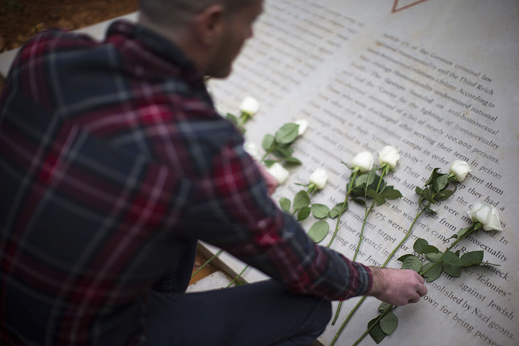 A man lays a white rose at a memorial inaugurated to lesbian, gay, bisexual, and transgender victims of the Holocaust on January 10, 2014 in Tel Aviv, Israel. 