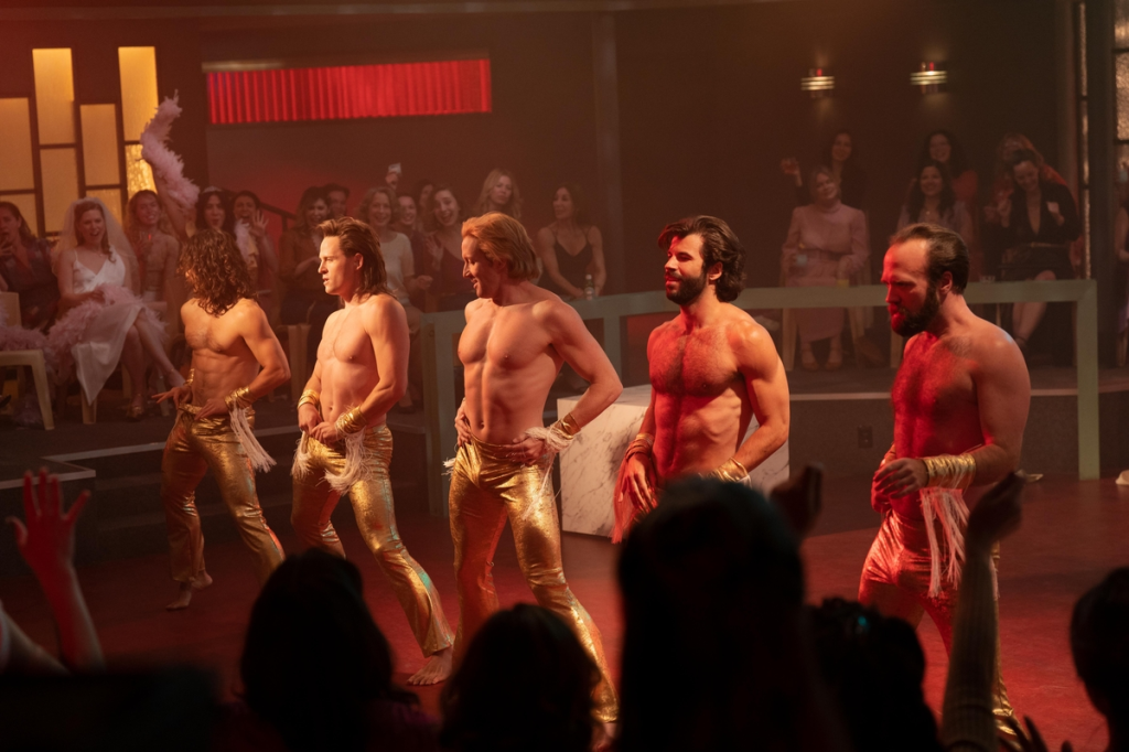 A still from US series Welcome to Chippendales shows five strippers performing in front of a crowd