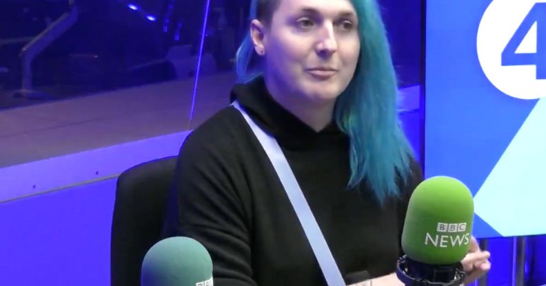 Laura Kate Dales wears a dark top and has blue long hair with an undercut while appearing during a BBC Radio interview discussing Gender Recognition Certificates