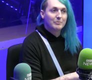 Laura Kate Dales wears a dark top and has blue long hair with an undercut while appearing during a BBC Radio interview discussing Gender Recognition Certificates