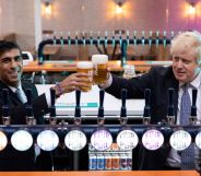 Boris Johnson and Rishi Sunak holding glasses on beer behind beer taps